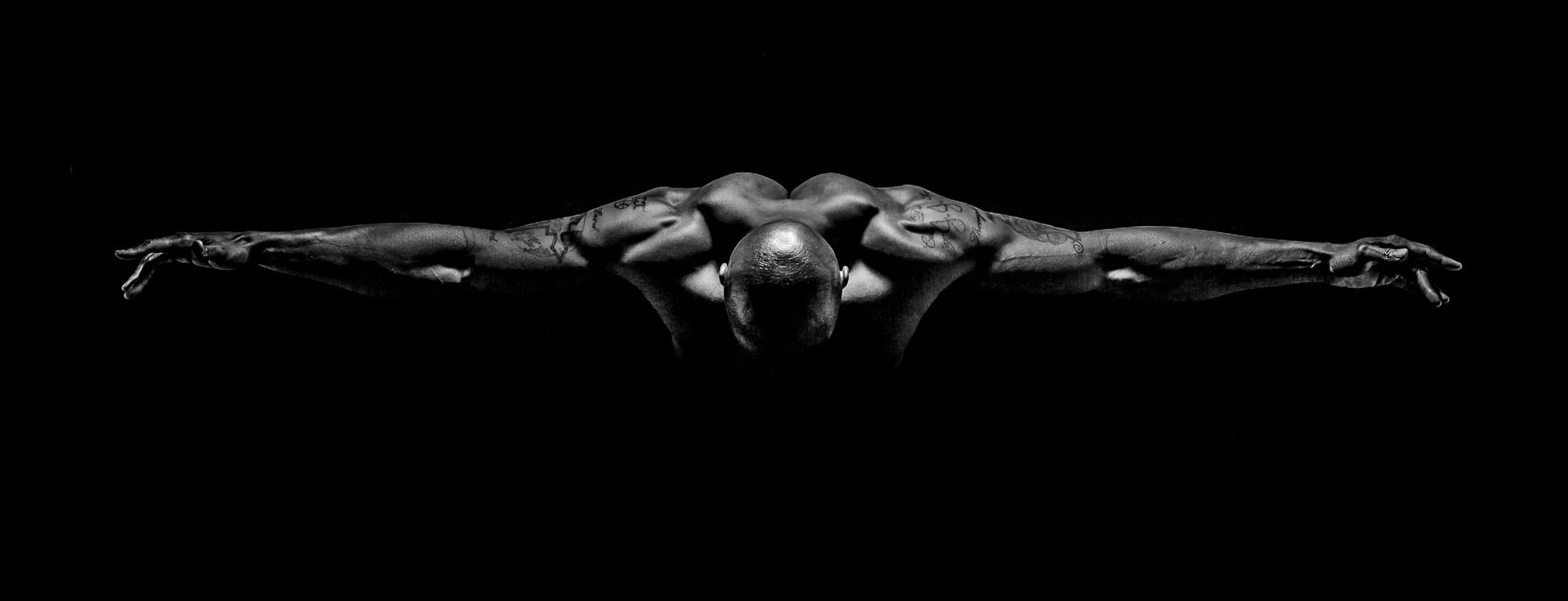 J.J. Johnson, shirtless, takes a bow, arms spread wide.