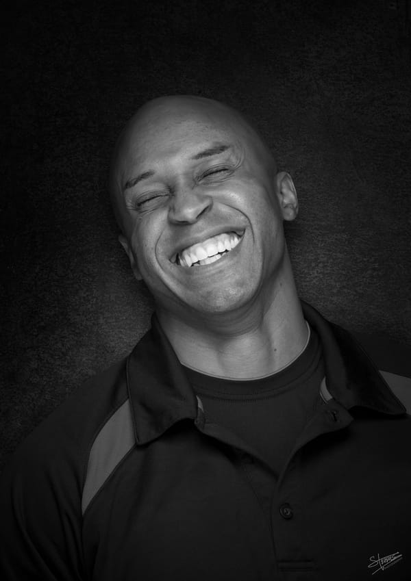 J.J. Johnson, eyes closed, head tilted back slightly, smiling broadly.