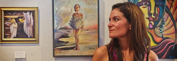 Sara Miles stands in front of a few of her paintings at the Alpine Artwalk.