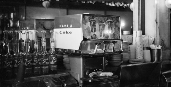 Vintage soda machine in black and white.