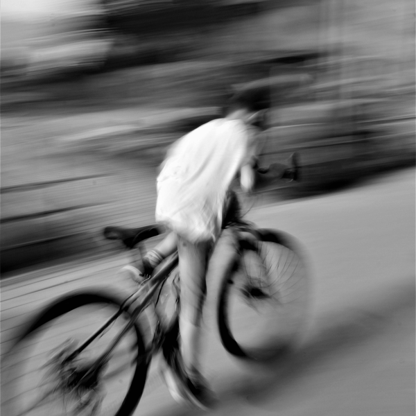 Boy on a bicycle with motion blur in black and white.