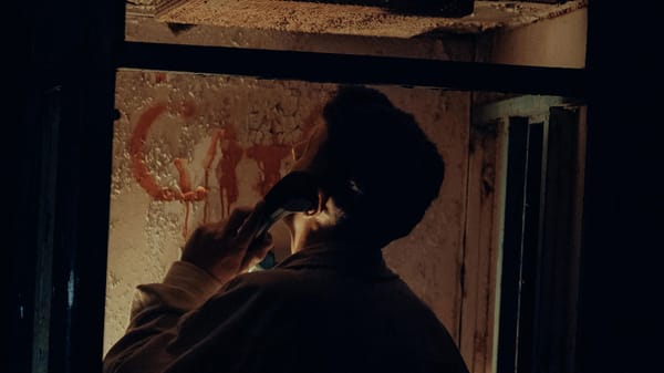 Man in abandoned phone booth.